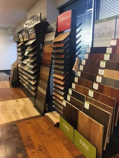 Showroom sample racks with wood-look flooring displays.