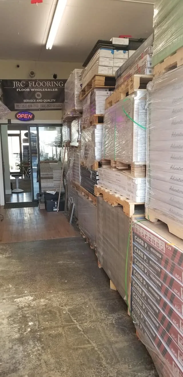 Stock aisle with palletized flooring boxes ready for delivery.